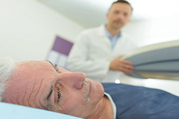 Homme étendu prêt pour la radiothérapie de son cancer de la prostate
