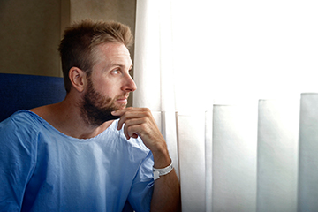 Homme en jaquette d'hôpital avant ses tests de surveillance active de son cancer de la prostate